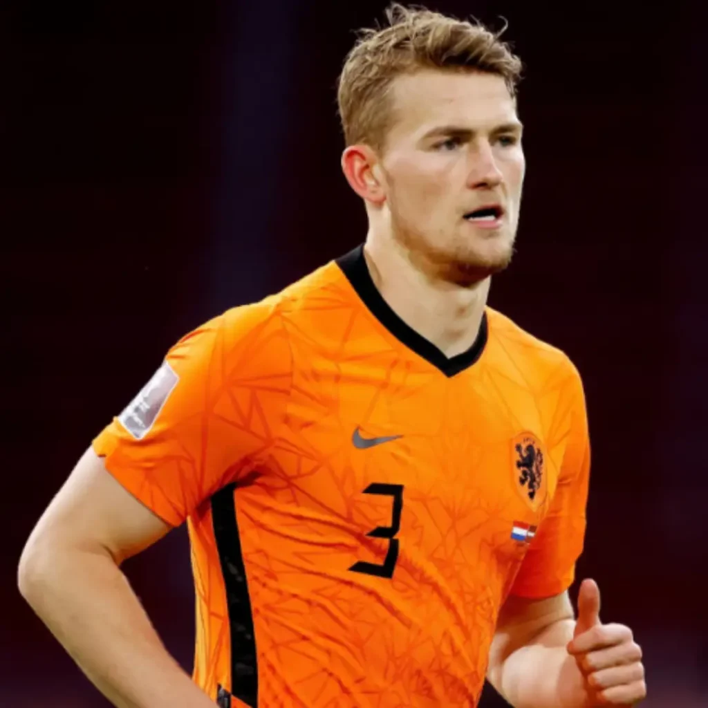 Manchester United's Matthijs de Ligt wearing a Holland jersey, standing confidently on the pitch after his transfer from Bayern Munich. Matthijs de Ligt