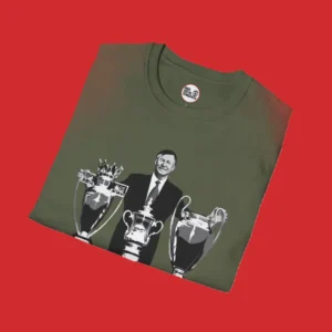Close up of green T-shirt featuring image of Sir Alex Ferguson and his amazing achievement of winning the treble in 1999 as Manchester United manager.