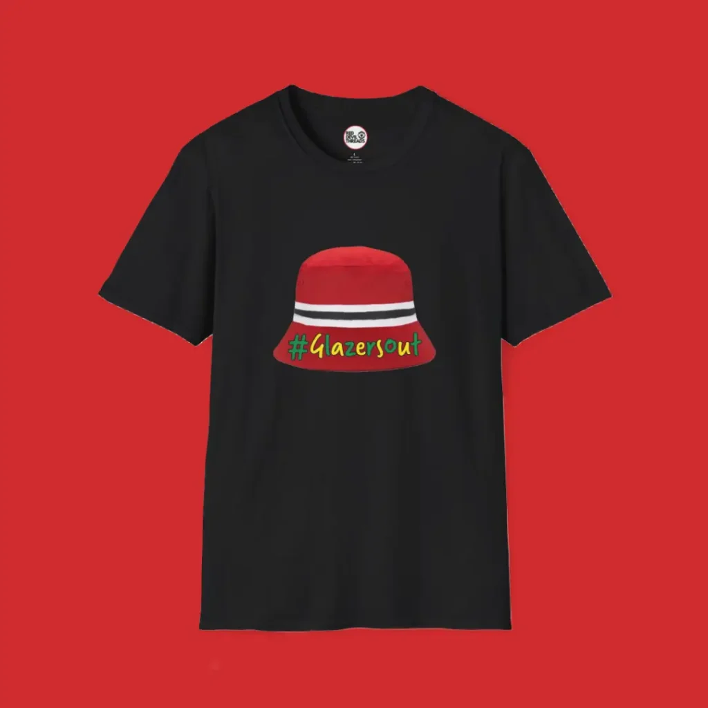 Black Manchester United fan T-shirt featuring the iconic red, white, and black bucket hat worn by Kobbie Mainoo during FA Cup celebrations, with green and gold "#GlazersOut" text.