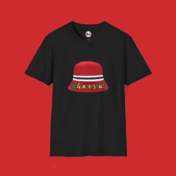Black Manchester United fan T-shirt featuring the iconic red, white, and black bucket hat worn by Kobbie Mainoo during FA Cup celebrations, with green and gold "#GlazersOut" text.