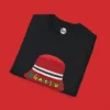 Folded black Manchester United T-shirt featuring the FA Cup celebration bucket hat design with green and gold "#GlazersOut" message.